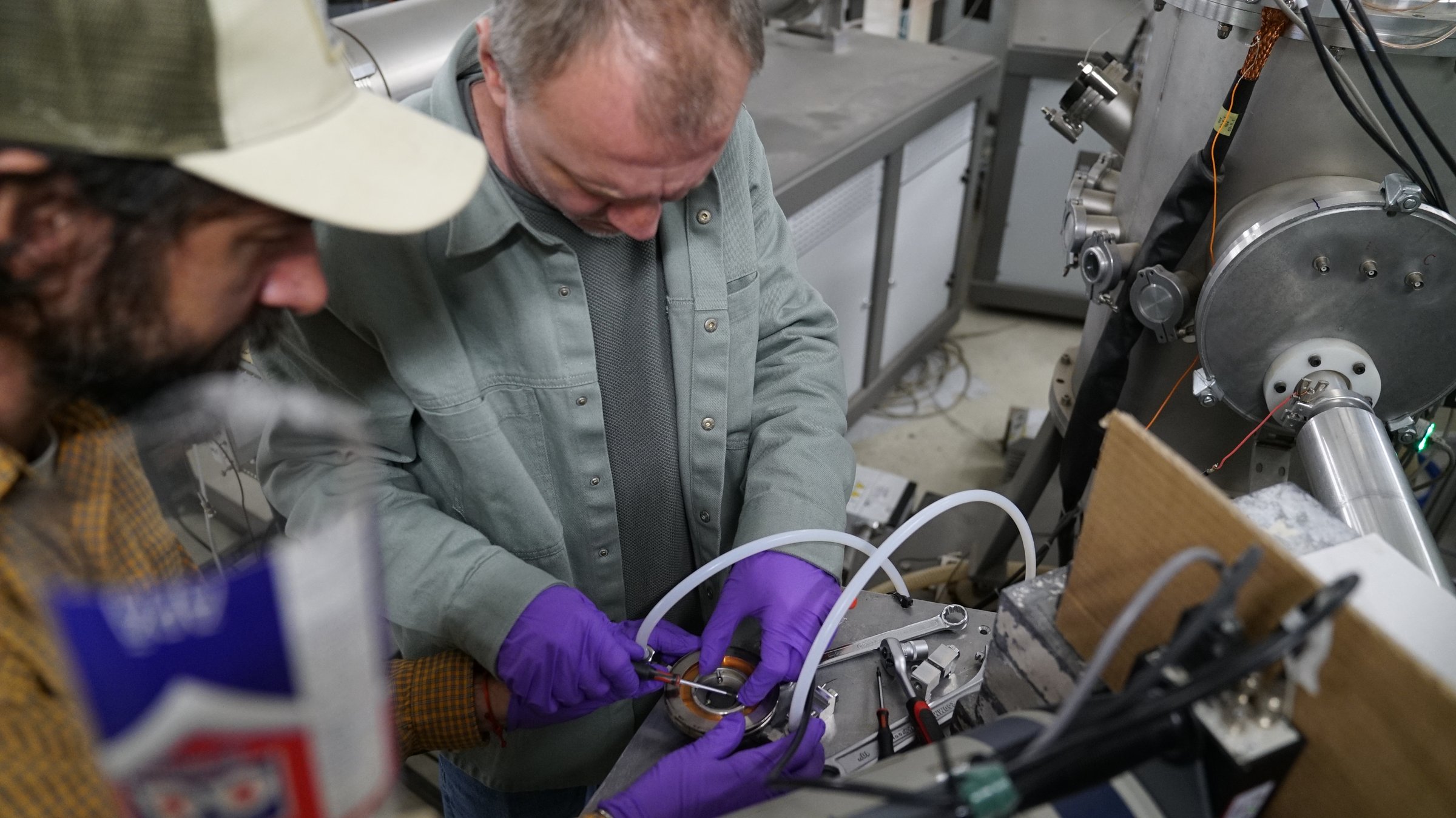 Two DFNA researchers servicing a component at the 3 MV Tandetron beam line