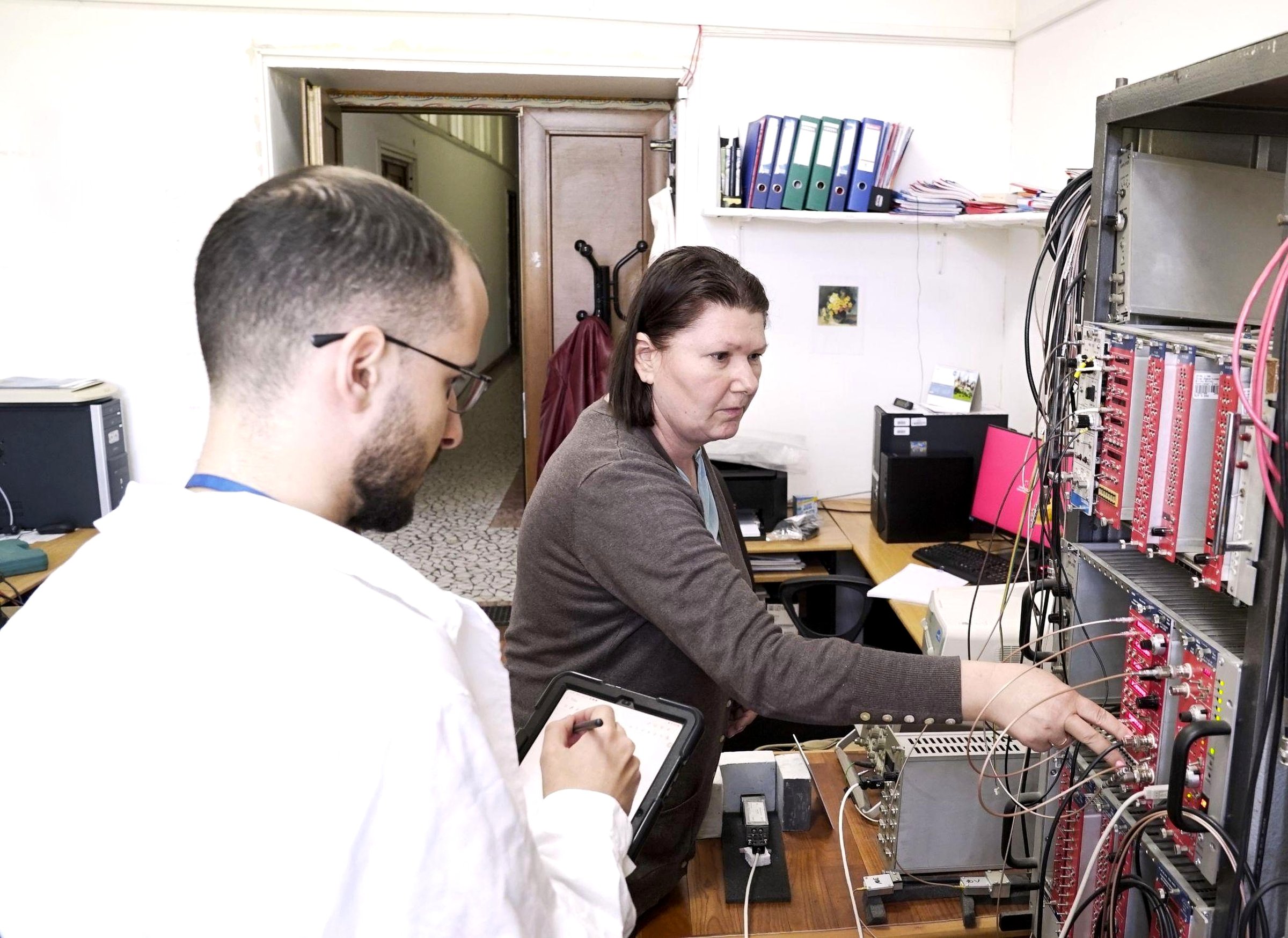 Researchers configuring the NaI(Tl) and CsI(Tl) scintillator spectrometry setup at the NIM electronics rack