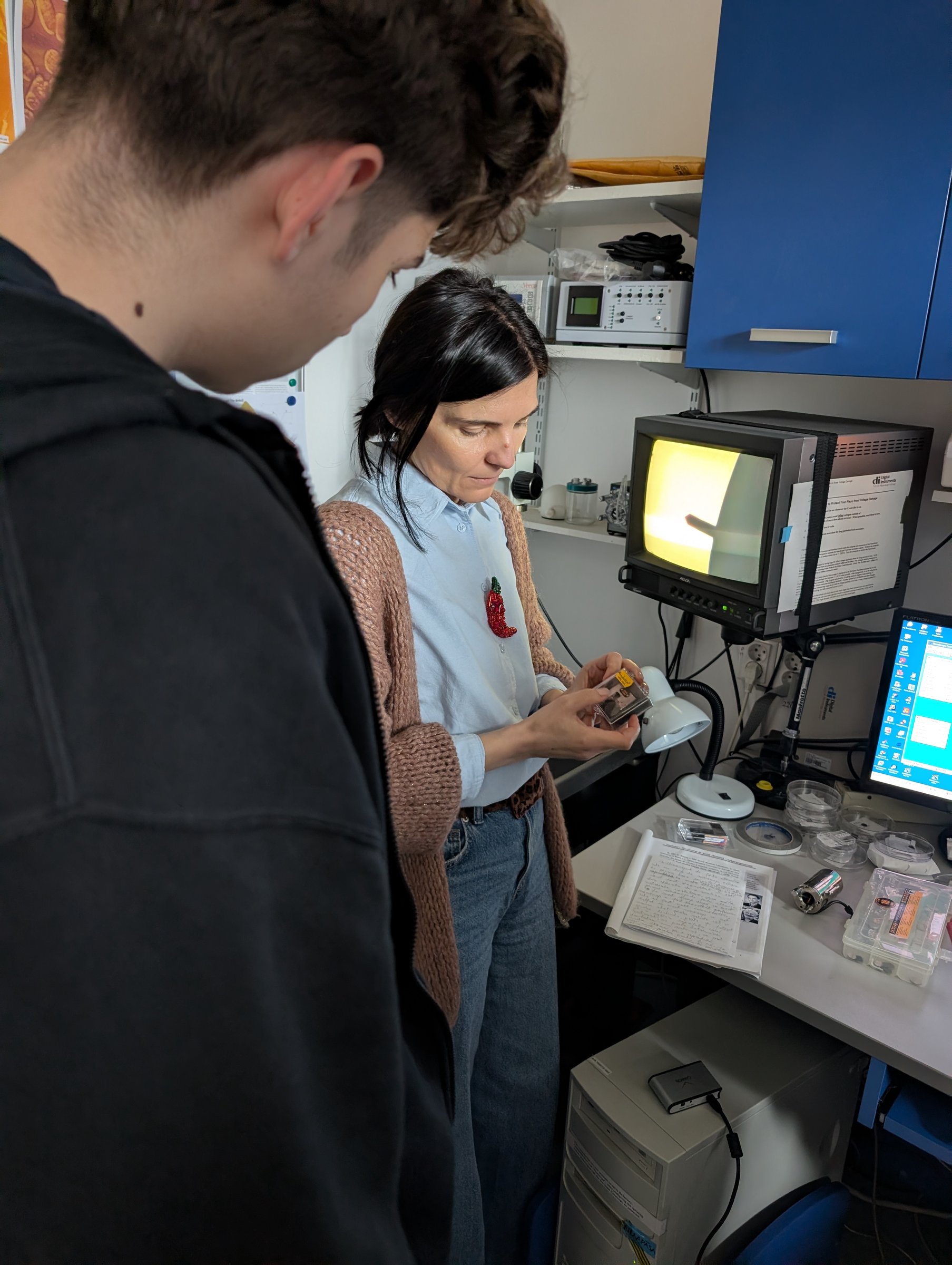 A researcher showing a visiting student a sample at the AFM workstation during a guided tour at TIESR