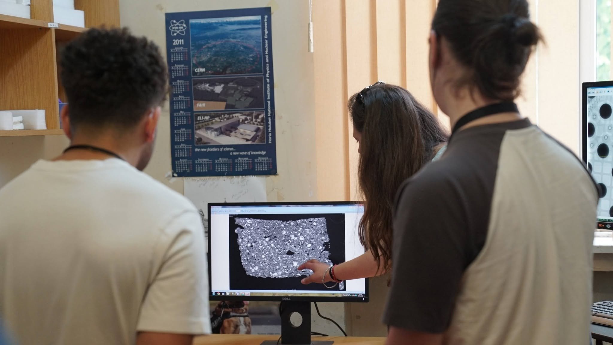 Visiting students examining an X-ray CT image on screen during a guided tour at TIESR