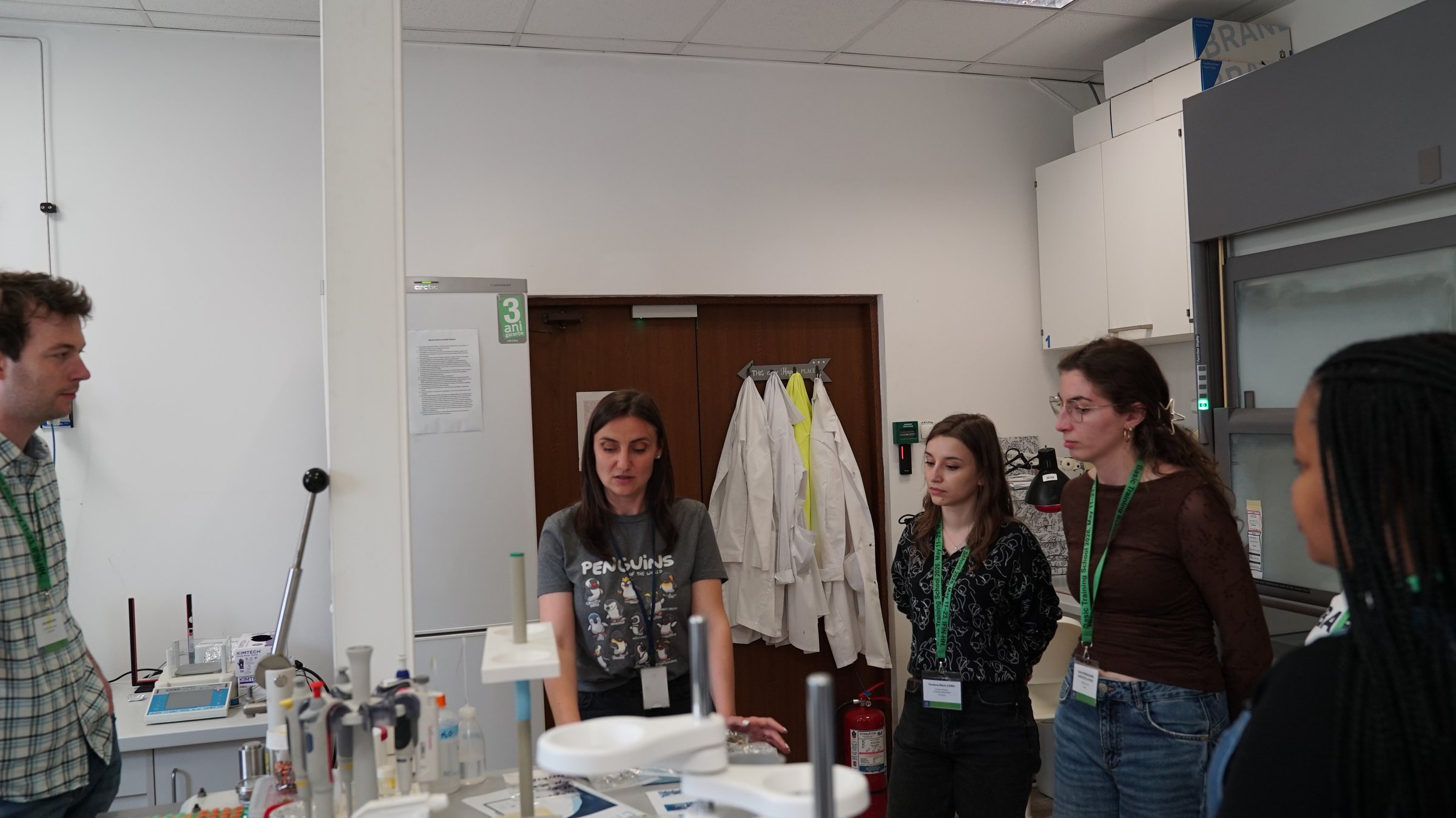 A DFNA researcher explaining cosmogenic-nuclide sample preparation to visiting students during a lab visit