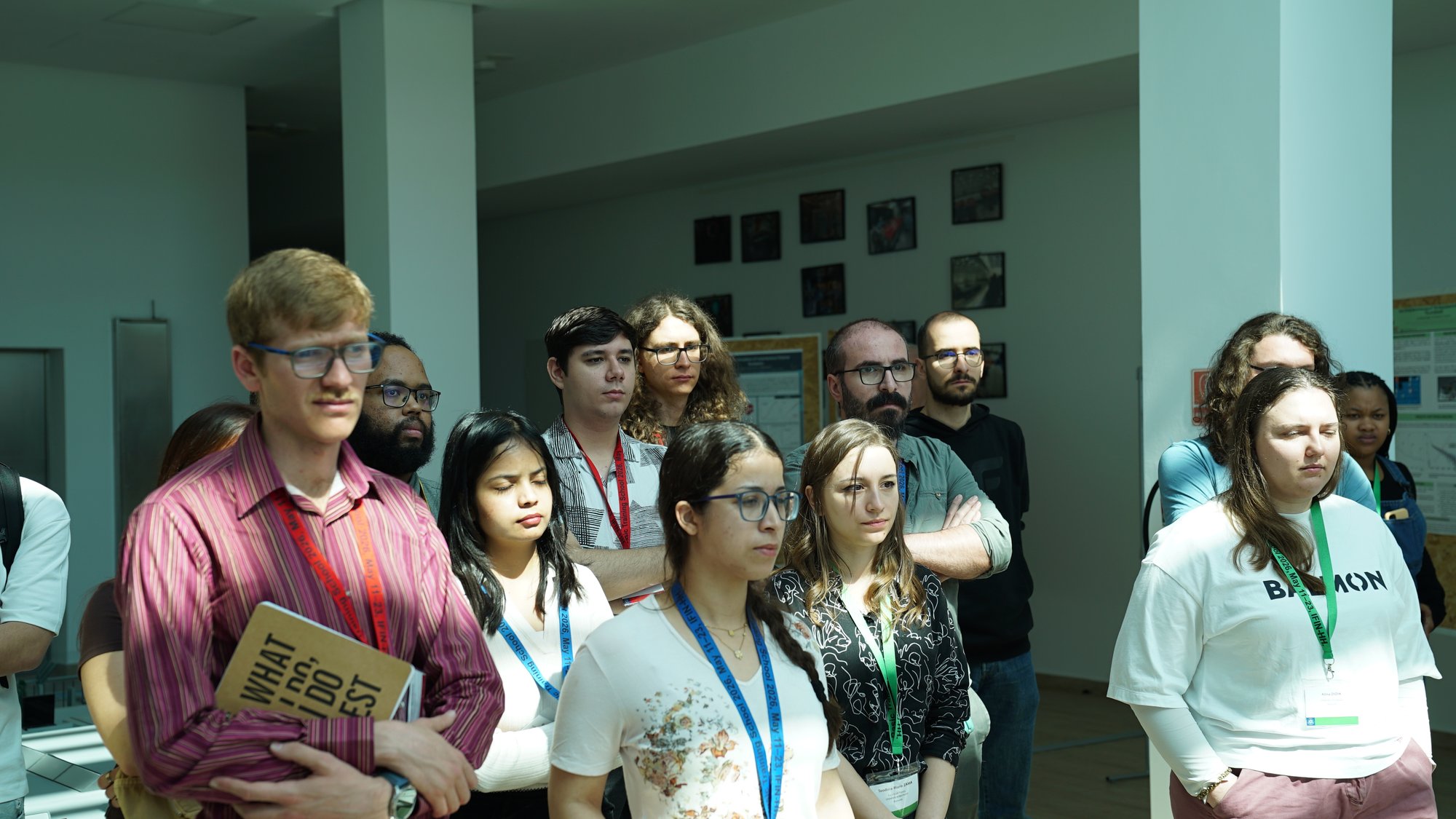 Trainees in the sunlit atrium beside the poster displays