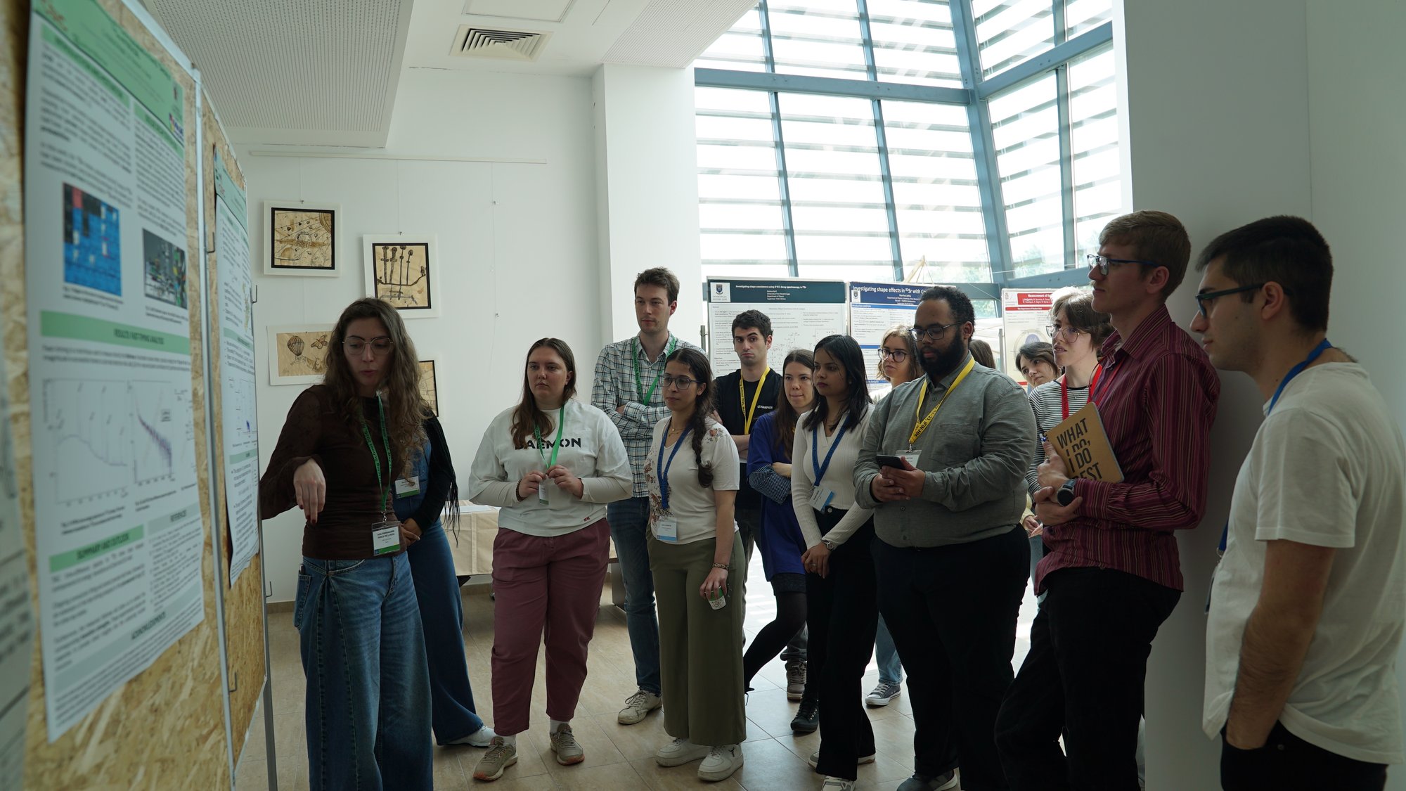 A large, engaged group of trainees discuss a research poster
