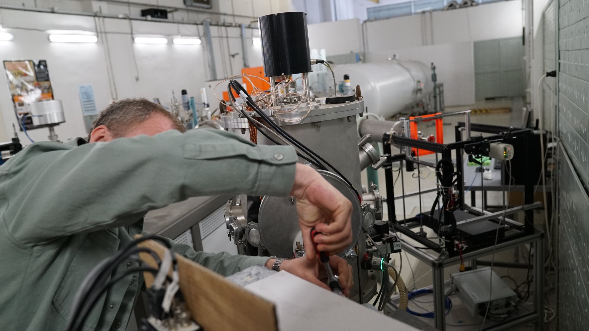 Close hands-on work adjusting wired instrumentation at the target-preparation rig