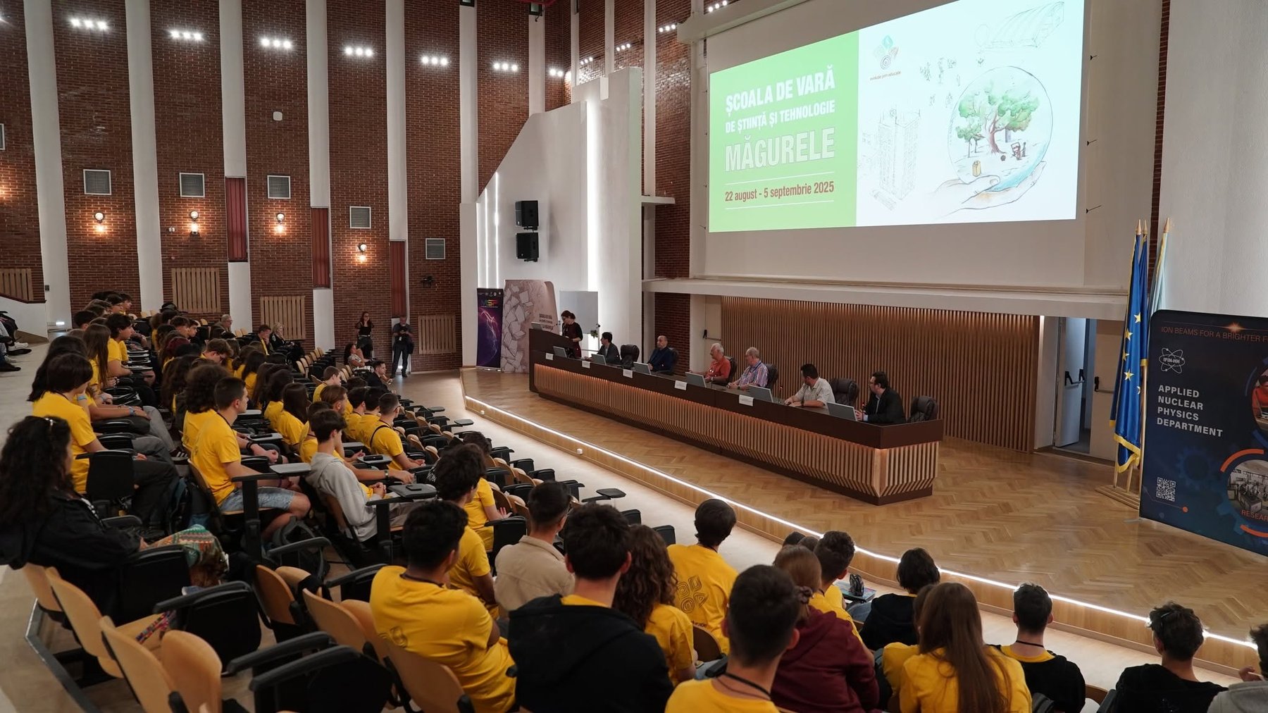 Opening of the MSciTeh summer school in the Faculty of Physics aula, with the DFNA banner on stage