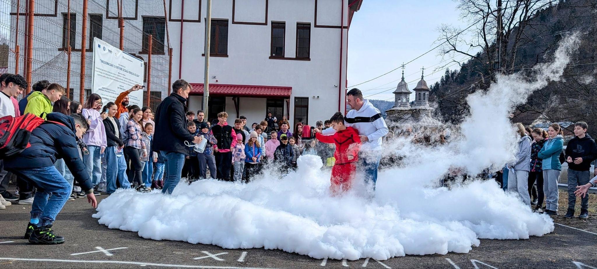 A dramatic dry-ice cloud demonstration in a schoolyard during the ReCoNnect Science Caravan at Azuga