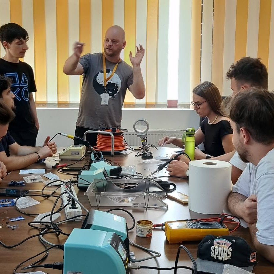 Students at a hands-on electronics and soldering workshop, guided by a DFNA researcher